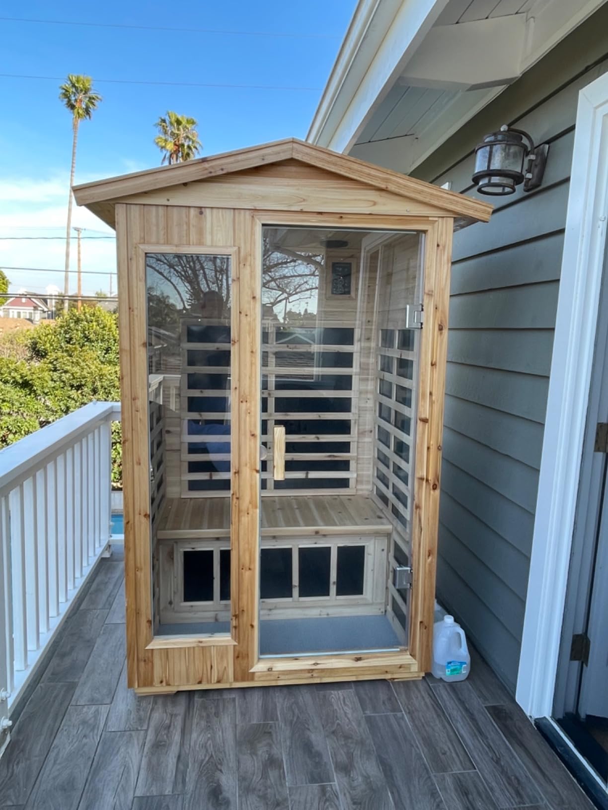 LTCCDSS outdoor sauna with a peaked roof installed on a raised wooden deck